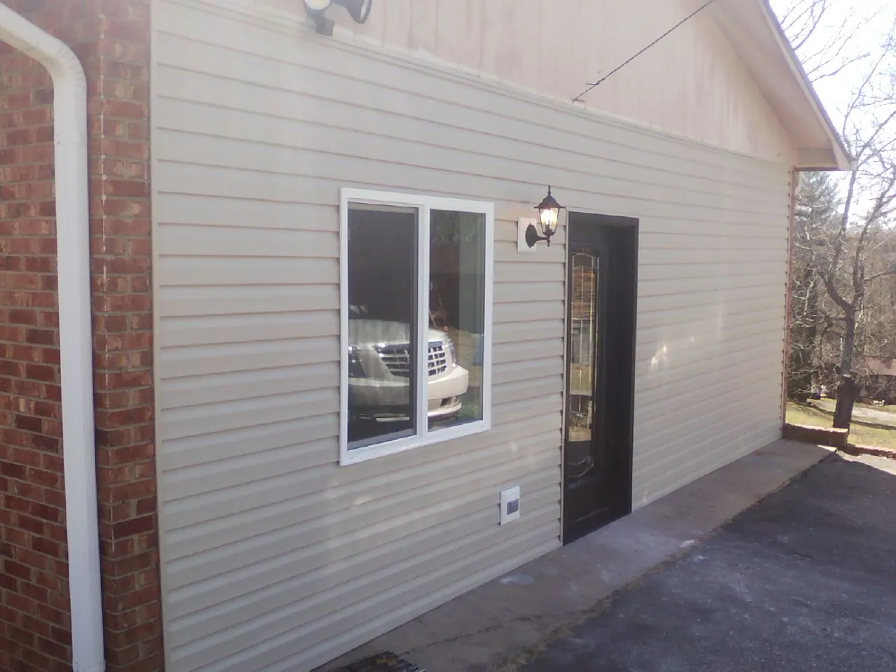 New vinyl siding and entry door on a room addition in Blanchard