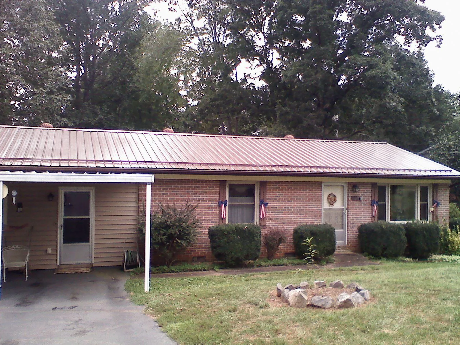 Bronze metal roof and carport on a brick ranch home — Roof Repair work by our crew in Blanchard